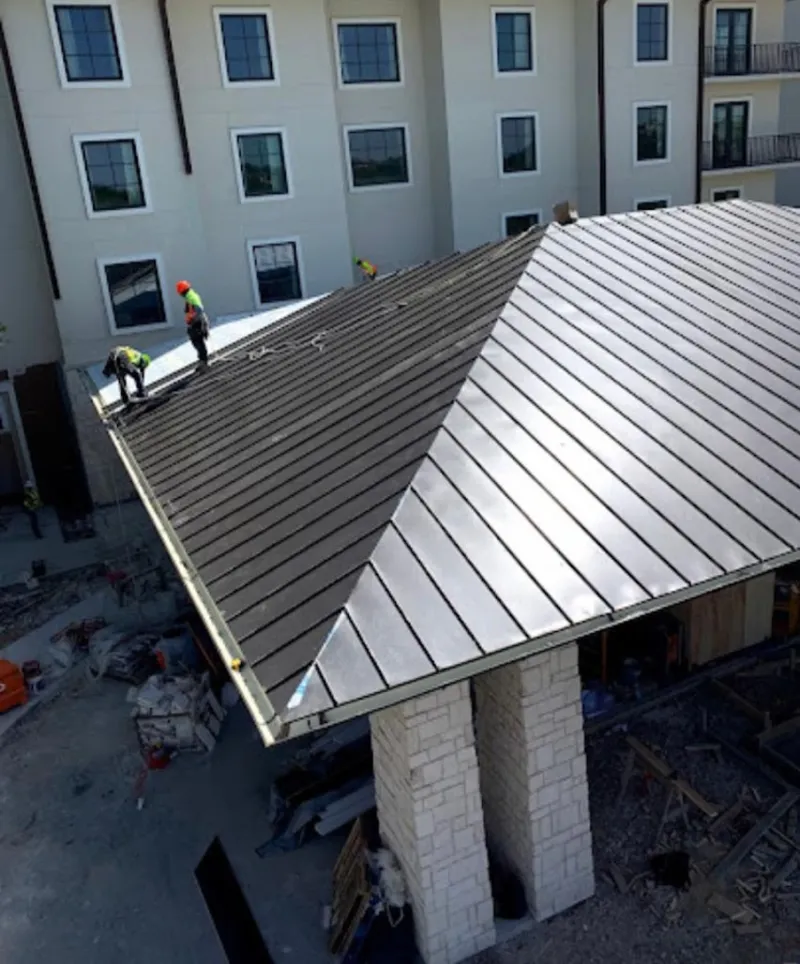 Crew installing standing seam metal roof panels on a commercial project in Albuquerque